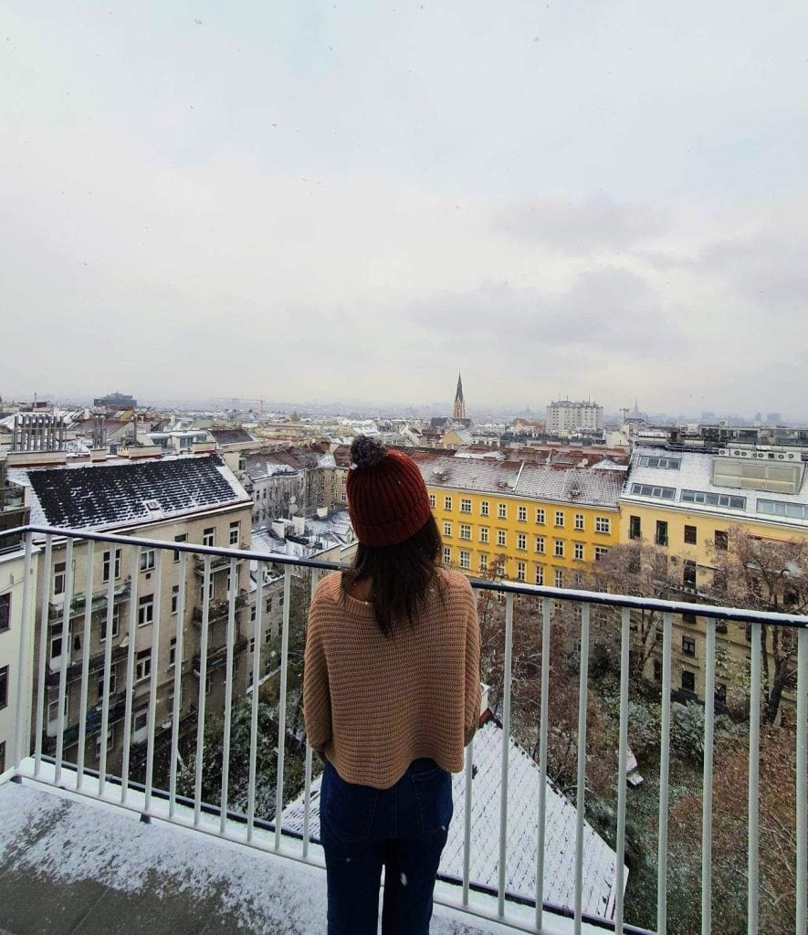 Lady overlooking a balcony in Snowy Vienna